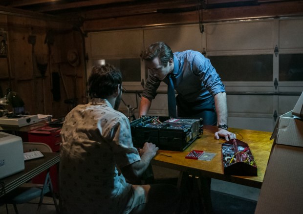 A scene from the TV show Halt and Catch Fire. Two men are in a garage. They are looking into an open computer.